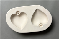 Cream-colored double-heart jewelry dish with two small stud earrings placed in each heart-shaped cavity.